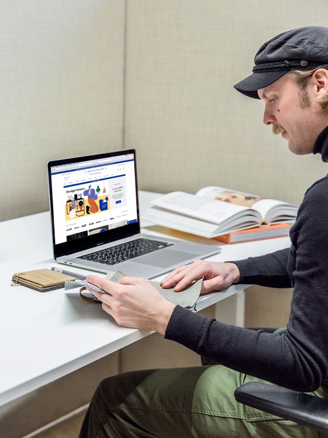 Designmyyjä Matias Rahkola selaa materiaalinäytteitä työpisteellään.