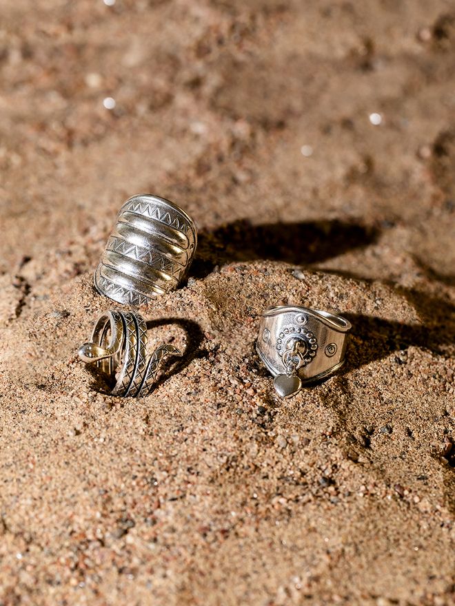 Kalevala Koru rings placed in sand.