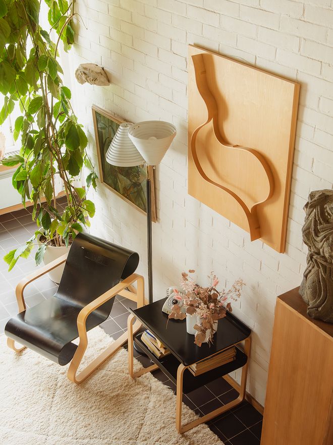 The entrance hall of Villa Skeppet, with white brick walls, dark tile flooring, and a bentwood lounge chair with black upholstery