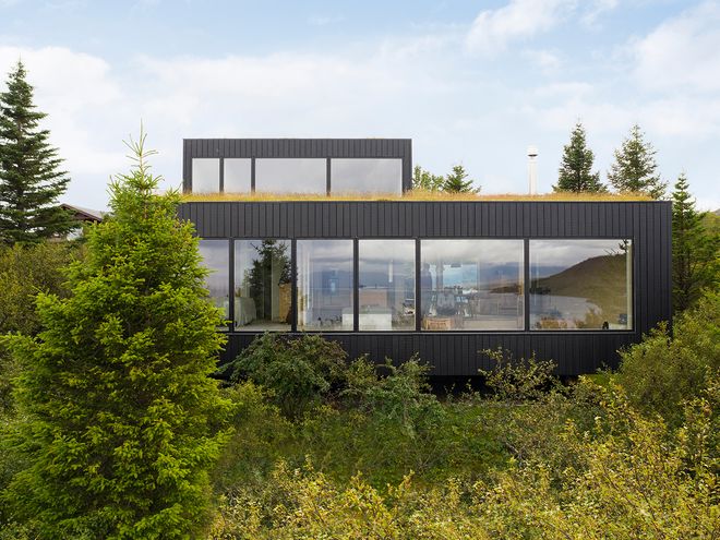 An image of the Holiday home by Þingvallavatn by KRADS architects: a leisure home located in Iceland in the middle of a picturesque scenery. This image features the building as viewed from the outside.