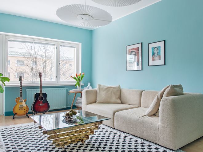 A living room with light blue walls and beige sofa