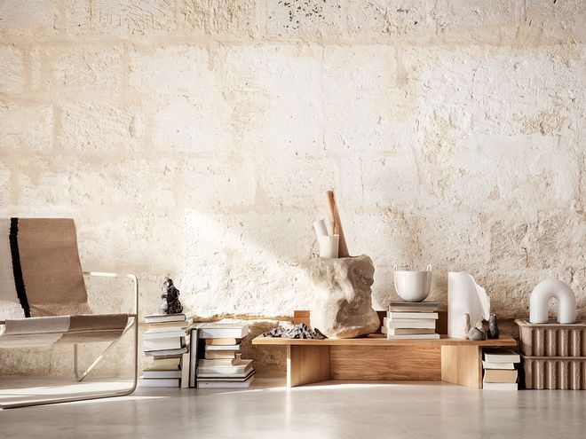 Ferm Living's Oblique bench stacked with books and ornaments.