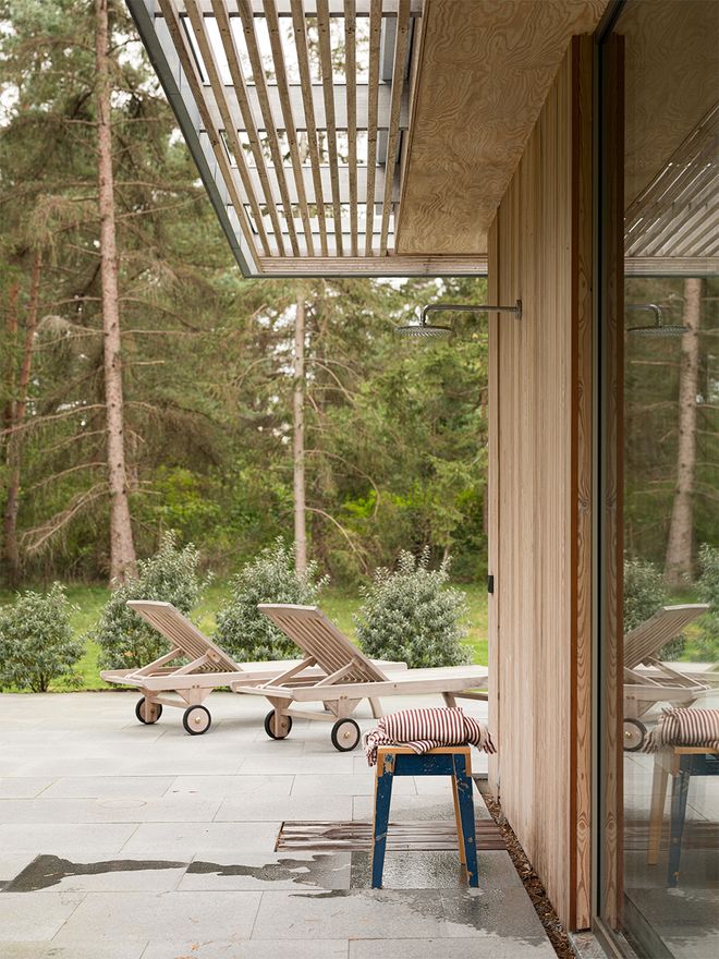 An image of Villa MSV, a private home located in Sweden. The image features the façade and an outdoor shower on the terrace of Villa MSV.