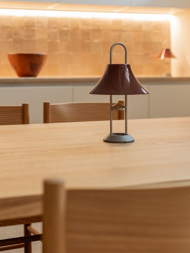 HAY’s Mousqueton lamp on a wooden table