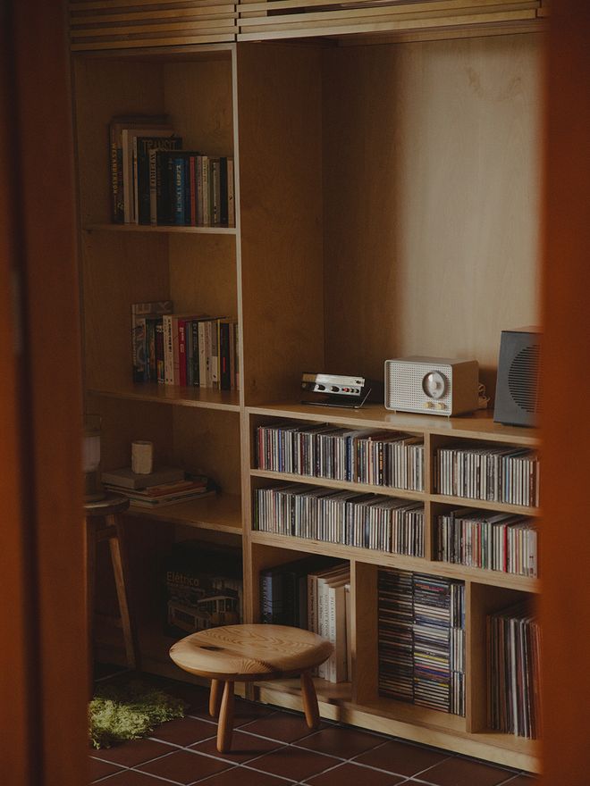 A shelf full of books, CDs and vinyls.