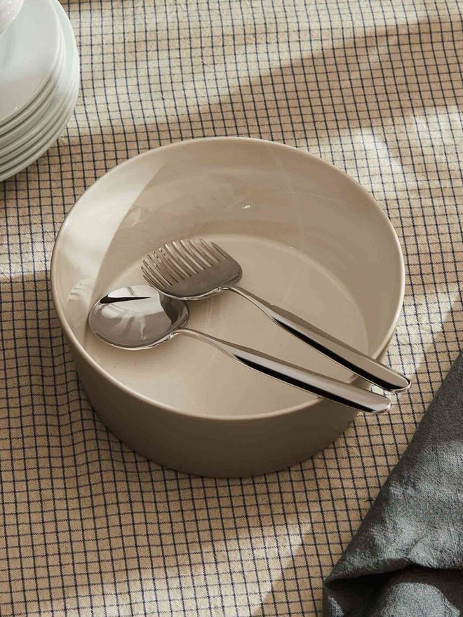Alessi Collo Alto salad server set by Inga Sempé, overhead view on a minimalist table setting