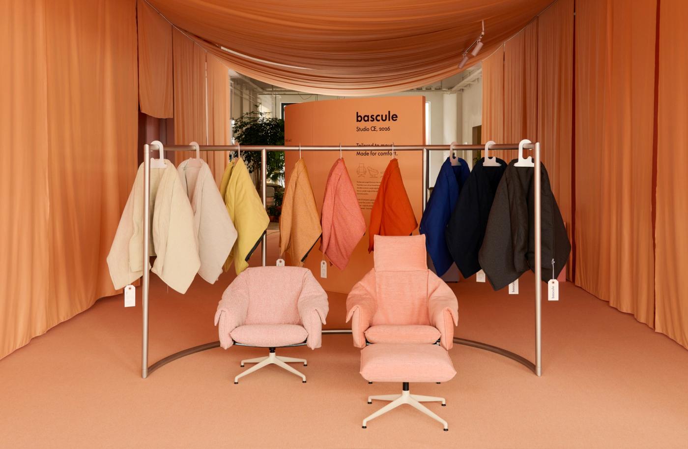Vitra trade fair stand with two Bascule lounge chairs surrounded by curved rails of removable covers in different colours.