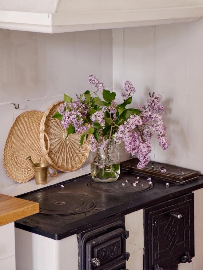 A wood-heated stove and lilac flowers