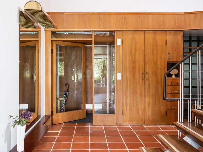 An image featuring Villa Ervi designed by architect Aarne Ervi. The photo shows the interior of the downstairs lobby with a staircase leading upwards.