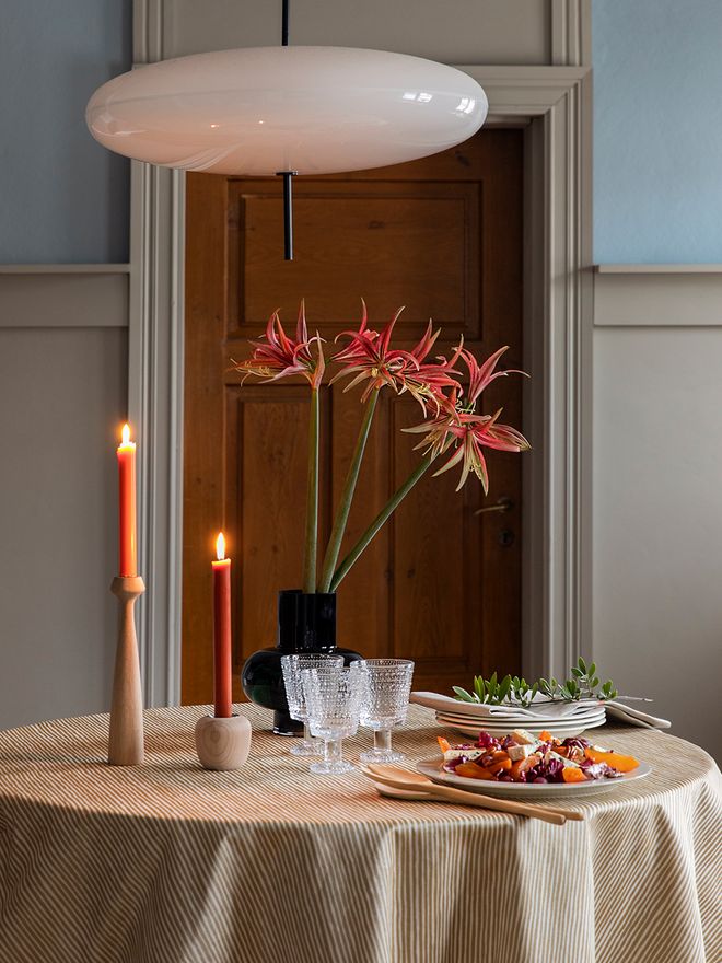 Two candles burning and a holiday table setting