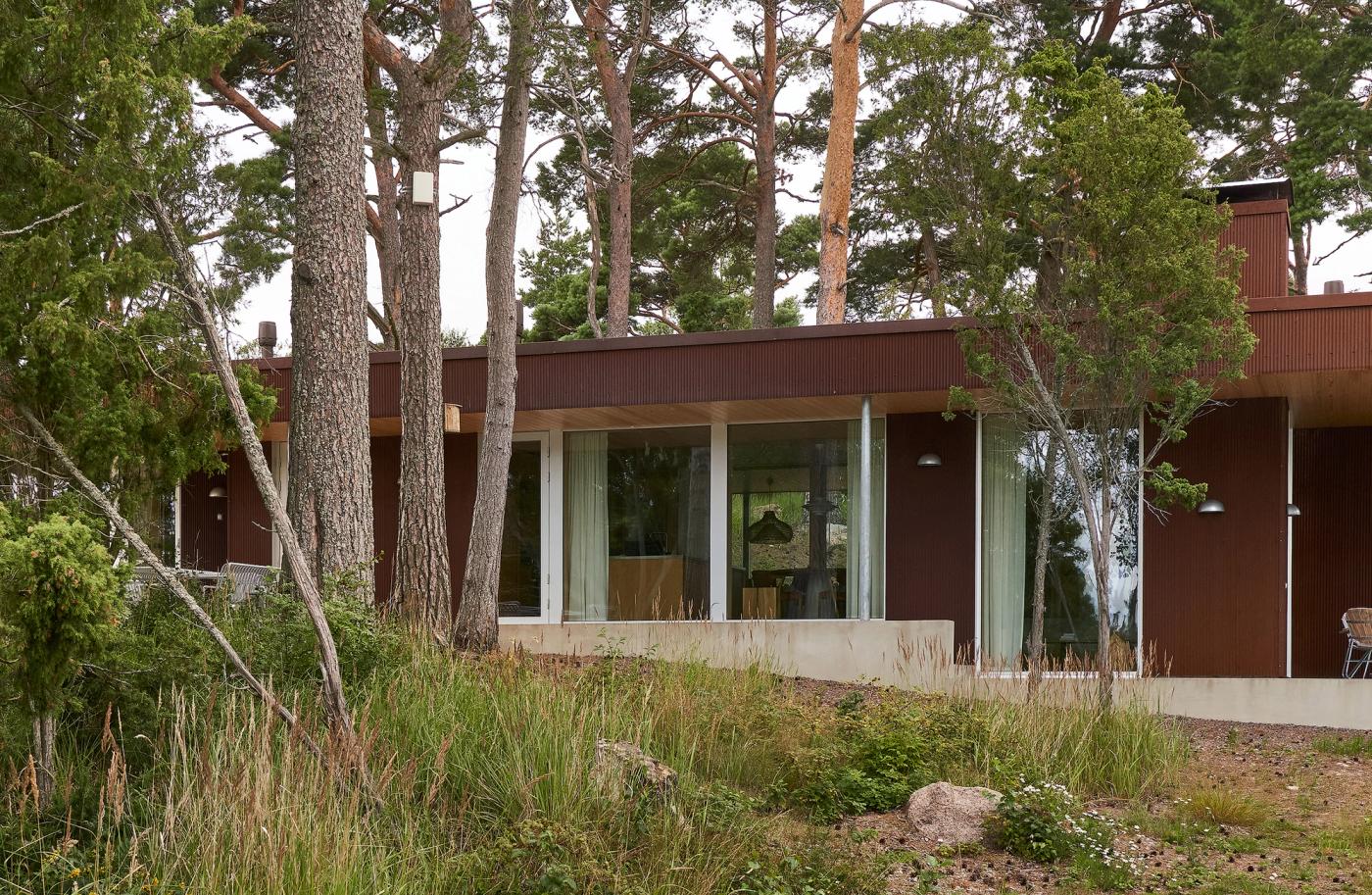 Ulkokuva kesäasunnosta, jossa punainen Corten-verhoilu