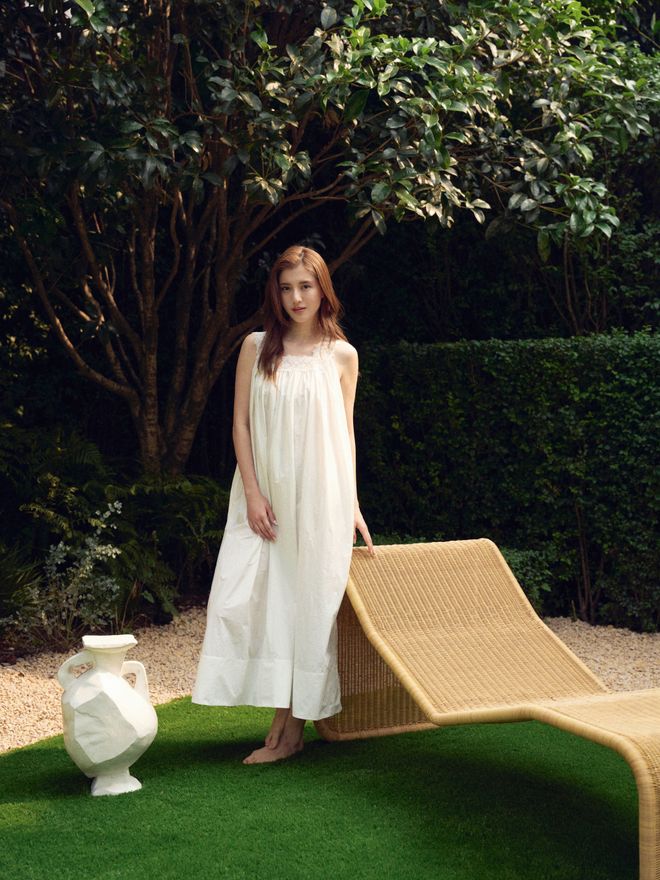 Karena Ng relaxing in her lush Shanghai garden beside a GUBI P3S Outdoor chaise longue