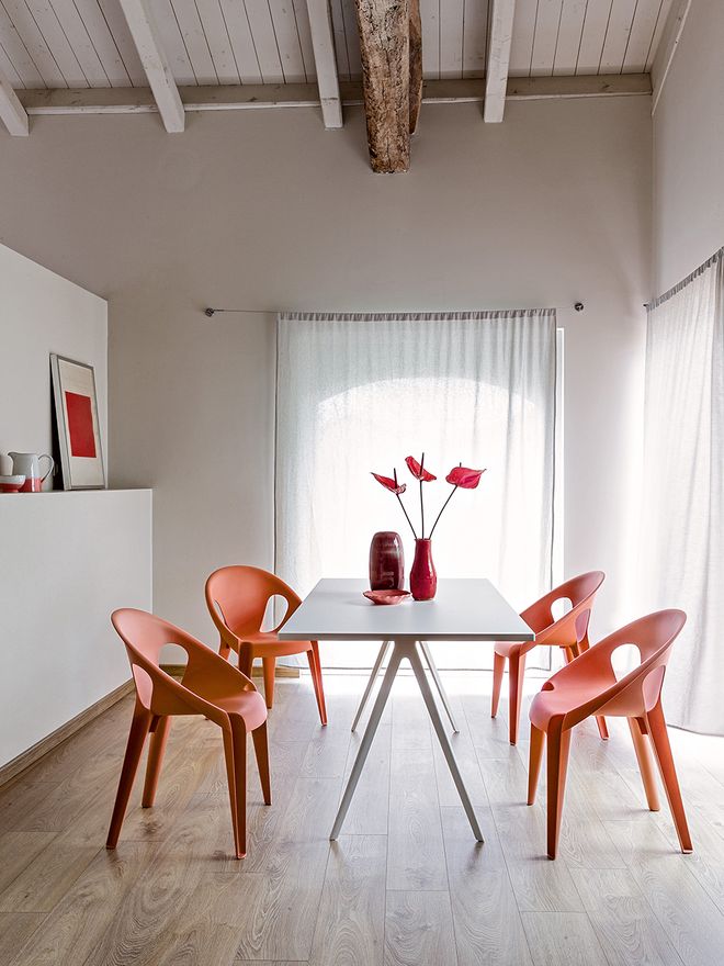Four red Bell chairs around the dining table
