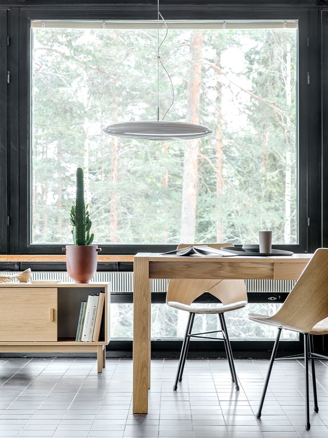 A dining space with Tapio Anttila's Jat-ko table and Limi chairs. In the background, a window with a forest view.