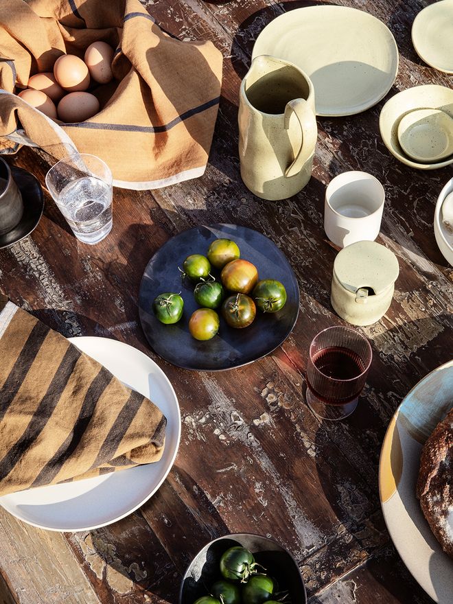 Ferm Living's Flow tableware in a table setting outdoors.