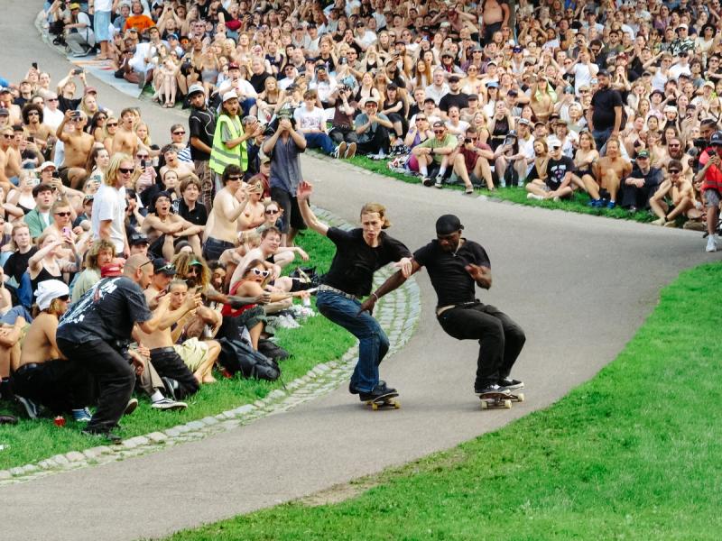 Two skateboarders race down the steep Sinebrychoff Park hill as a summer crowd lines the slope at the Vauhtikisat 2026 event in Helsinki.