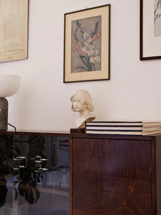 Artworks and a sculpture on a glass cabinet