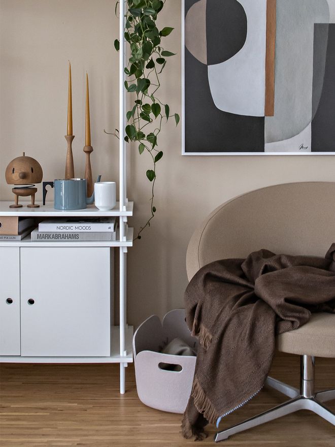 Kuva, jossa Muuton Restore-säilytyskori, ferm LIVINGin Herringbone-huopa ja applicatan puiset kynttilänjalat osana olohuoneen sisustusta.
