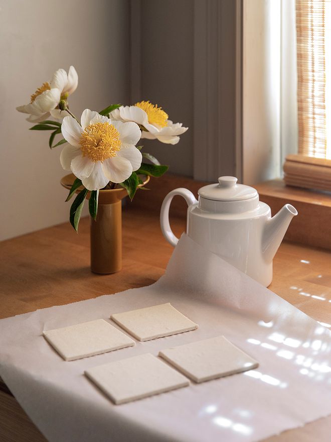 Flowers in a vase next to a teapot