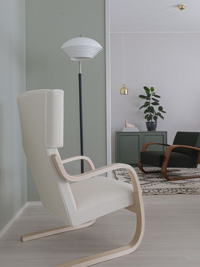 An image showcasing Artek's armchairs 401 and 400, floor lamp A811, and pendant lamp A330S as part of the living room decor.