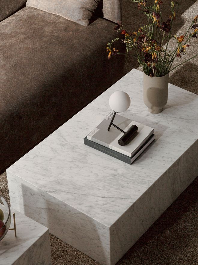 Menu's Plints table in white carrara marble, placed in the living room.