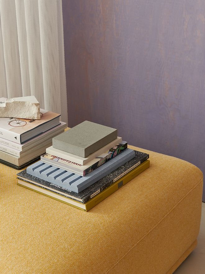 An image of Muuto's Connect sofa in yellow, against a purple wall, as part of the living room decor.