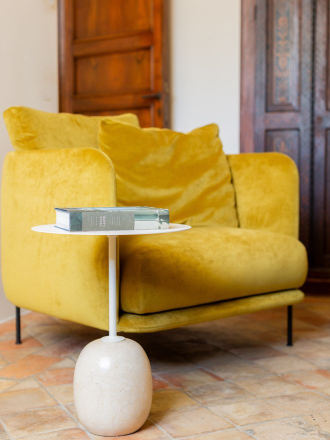 Yellow armchair and a light side table with a book on it