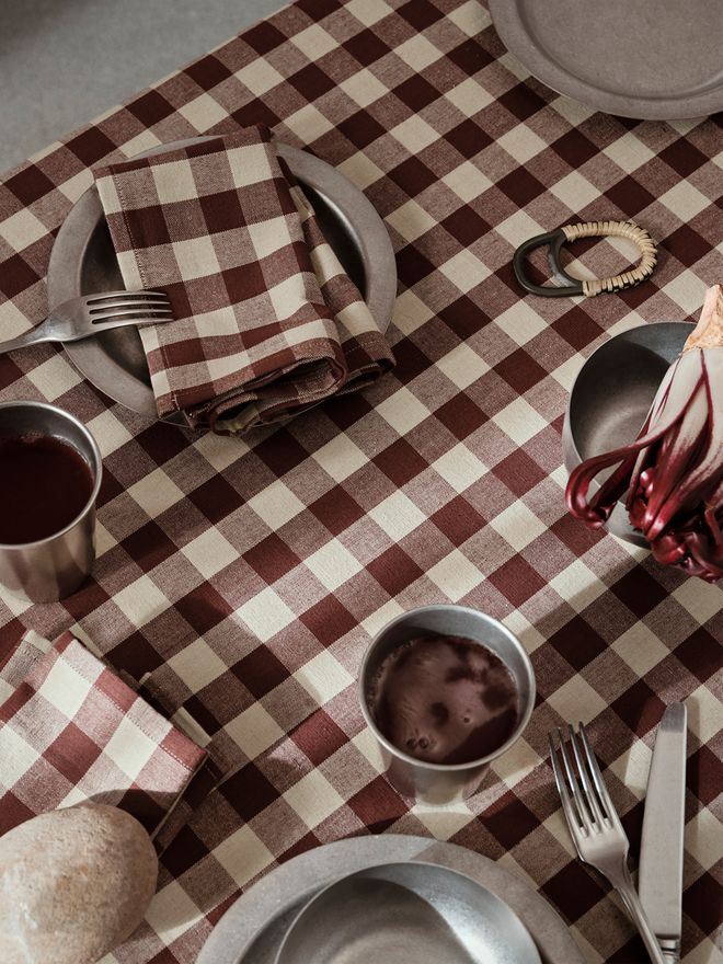A checked Ferm Living tablecloth and table settings
