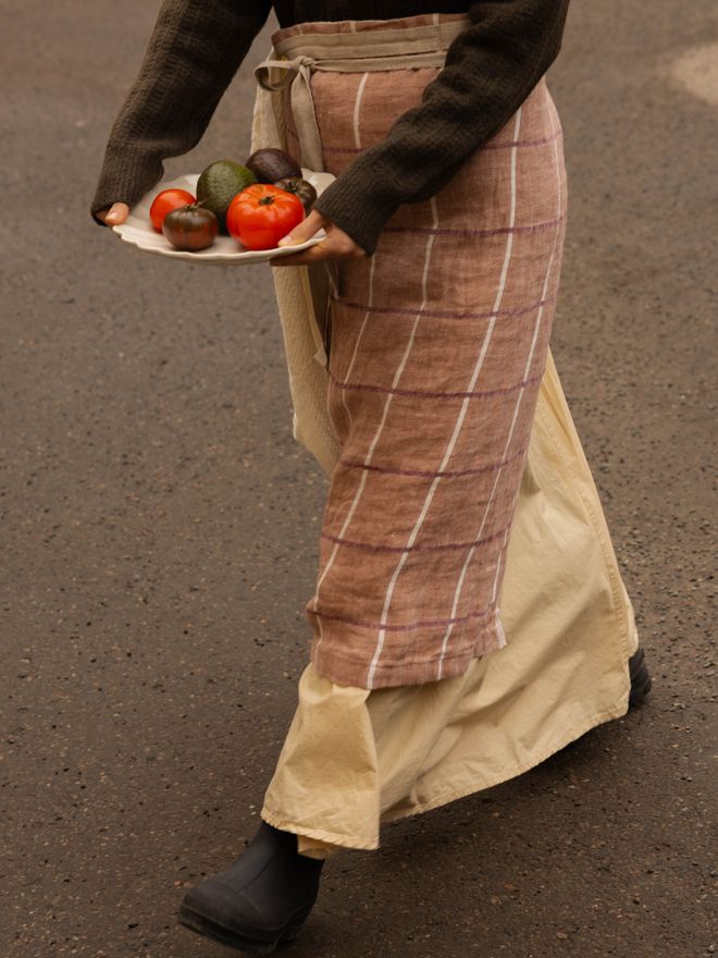 An apron made of checkered linen fabric, tied around a person's waist