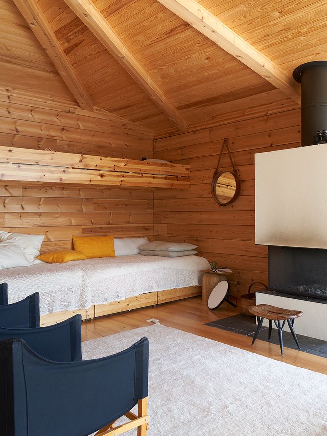 Built-in bunk beds along the back wall of the cabin, topped with Woodnotes Seaborn knits made from paper yarn and a stack of pillows.