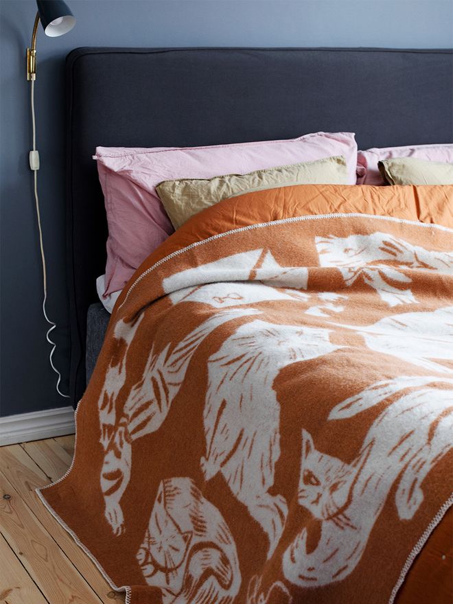 An image with the Kissanpäivät blanket by Lapuan Kankurit on the bed, as part of the bedroom decor.