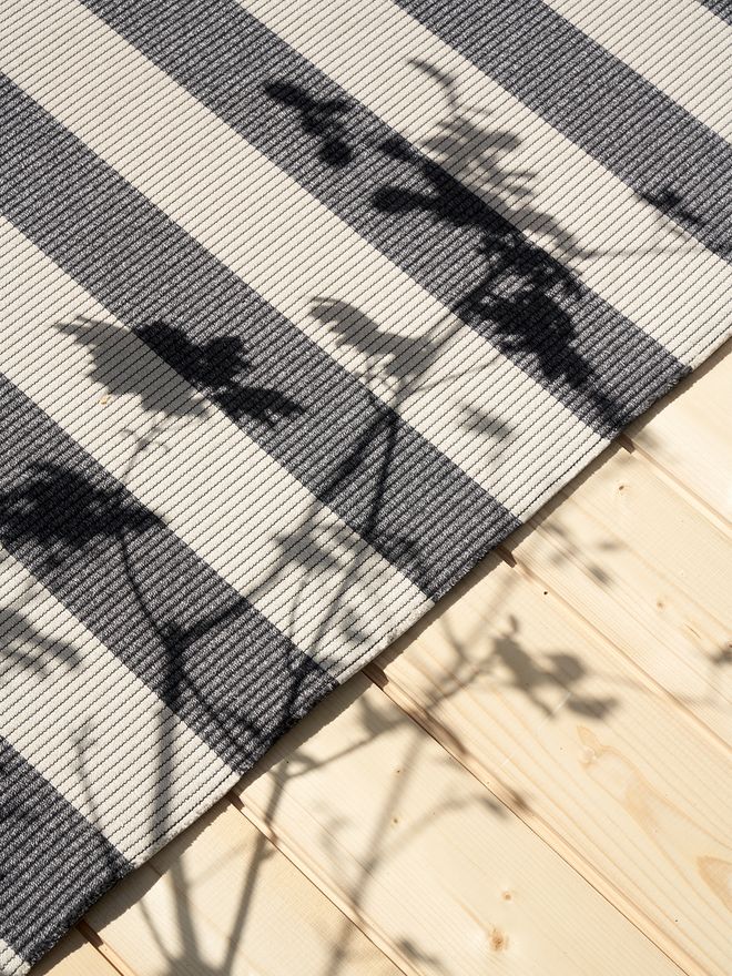 Big Stripe rug by Woodnotes against a wooden floor.