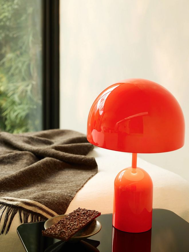 Tom Dixon’s orange Bell table lamp on a side table