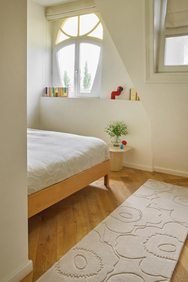 A bright room with a narrow, long runner rug featuring the light-colored "Piirto Unikko" pattern