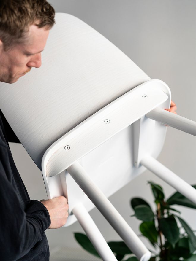 David Geckeler holding a white Nerd chair.