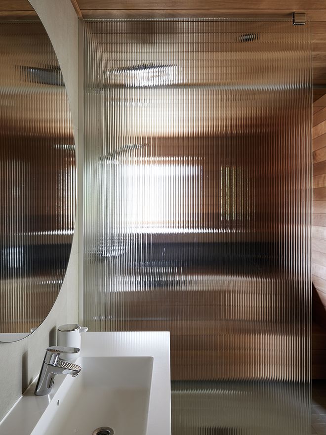 A bathroom with a fluted glass wall
