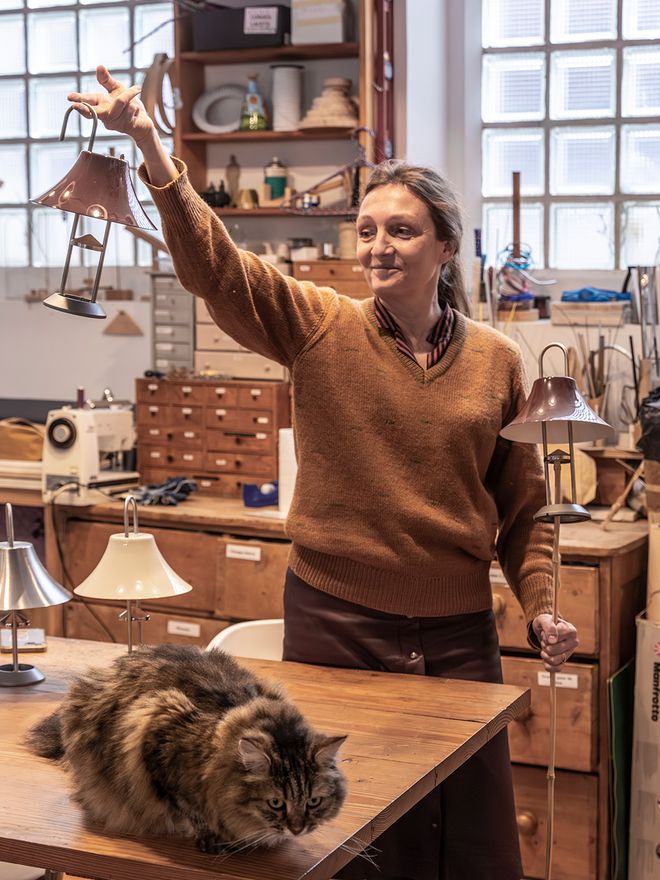 Inga Sempé holding HAY Mousqueton portable lamps in her studio workshop