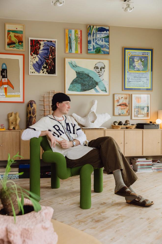 Portrait of Norwegian interior architect and designer Fredrik Bull in his Oslo home, sitting at the Ekstrem lounge chair, surrounded by art and crafted objects