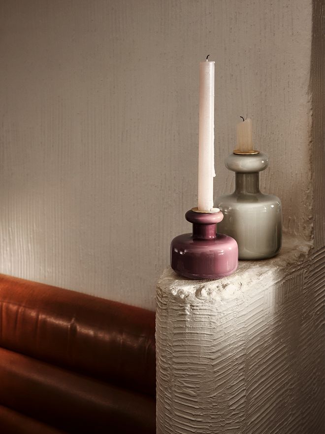 An image with Marimekko's burgundy Puteli candleholder and Plunta candleholder in a clay shade as part of the living room decor.