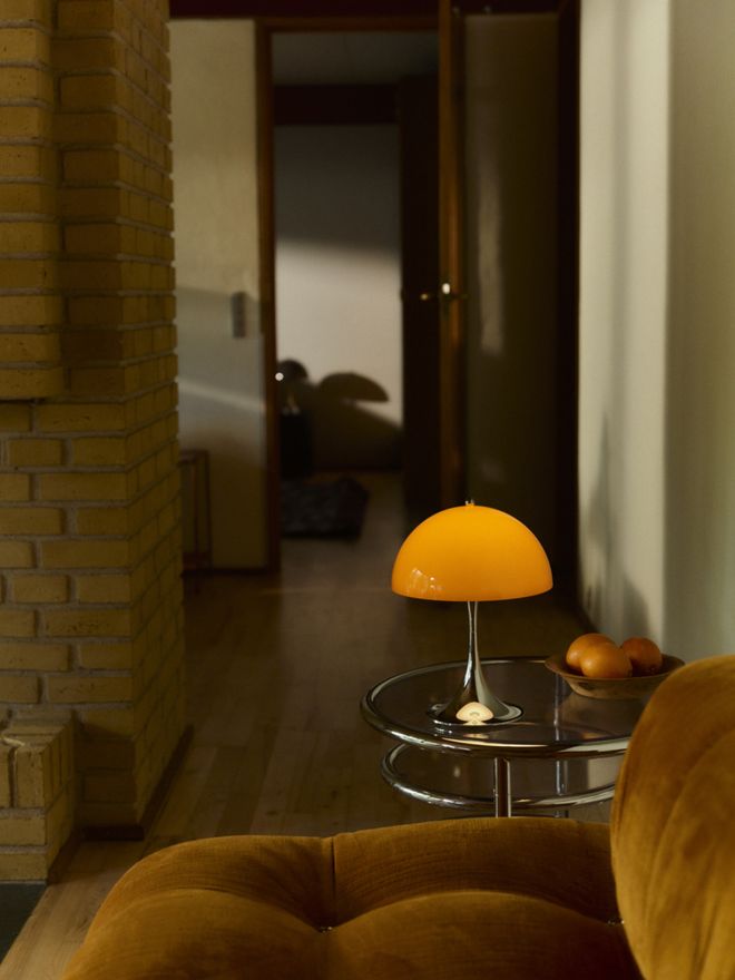 Close-up of Verner Panton’s iconic Panthella table lamp in opal orange highlighting its bold curves and vivid color palette