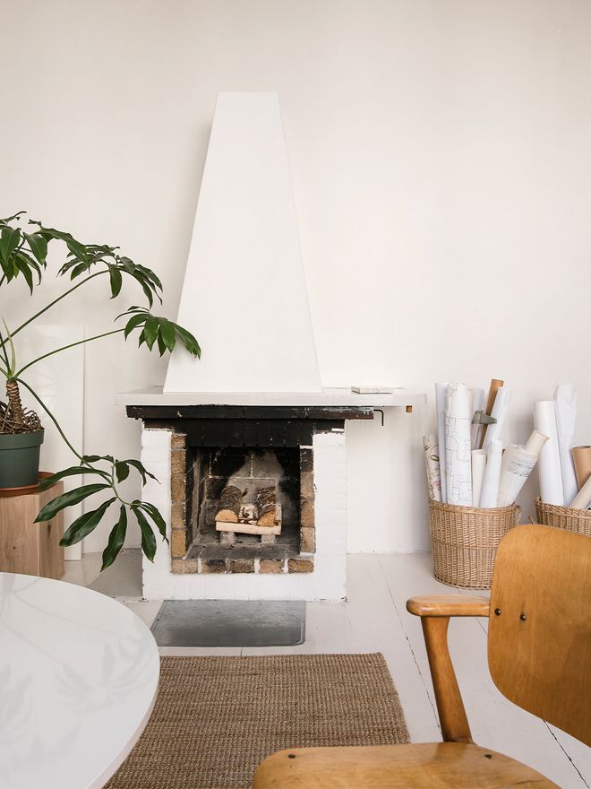 An image of a room, featuring an open fireplace and Ilmari Tapiovaara's Domus chair.