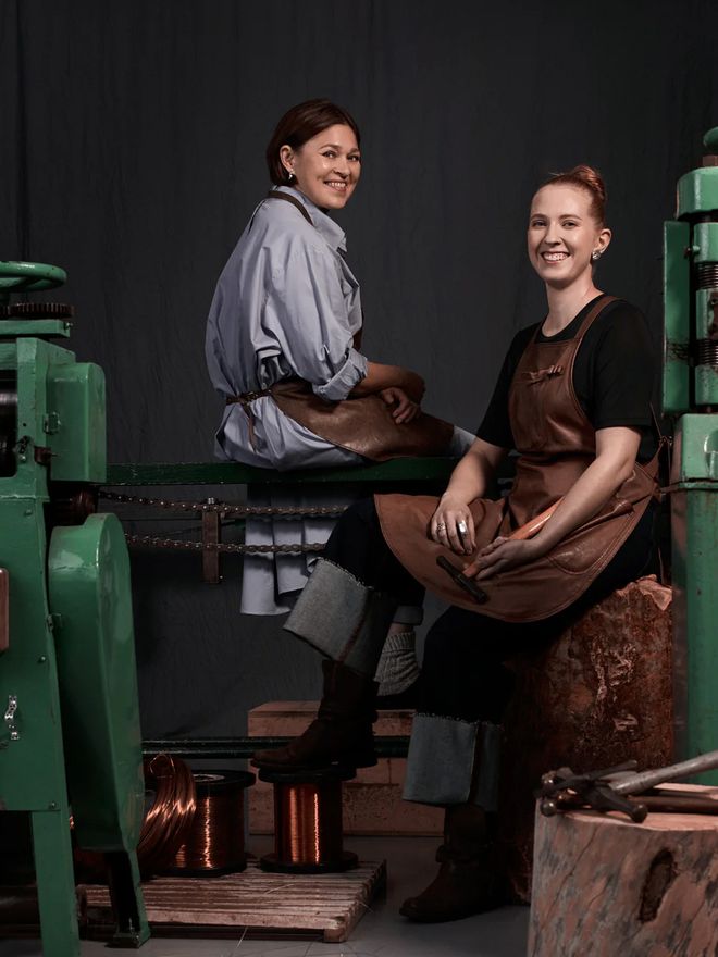 Two smiling employees photographed at the Kalevala Koru factory.