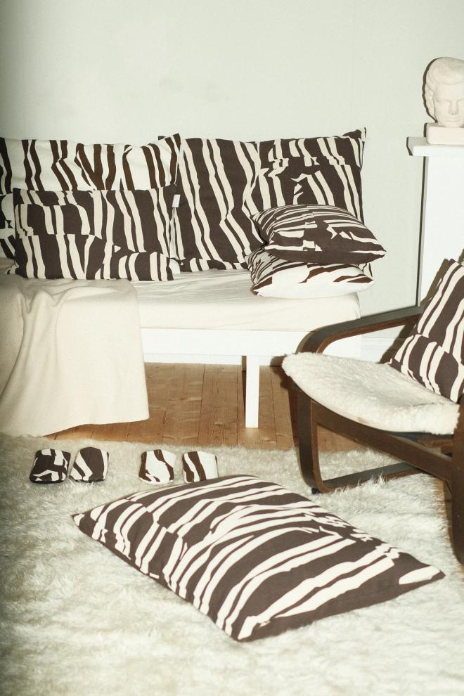 A sofa and floor cushions featuring a black-and-white organic In My Own Timee pattern, set in a light living room
