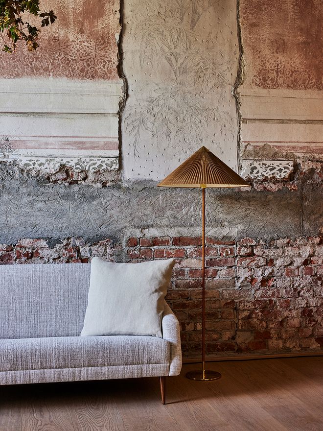 An image featuring GUBI's Paavo Tynell's 9602 floor lamp as part of the living room interior.