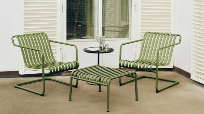 Two olive green Palissade Cantilever chairs placed in front of the balcony door