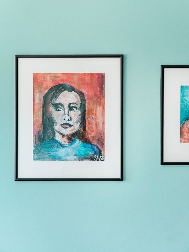 Paintings on a blue living room wall