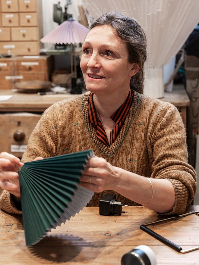 Inga Sempé adjusting the shade of a HAY Matin lamp in her Paris studio