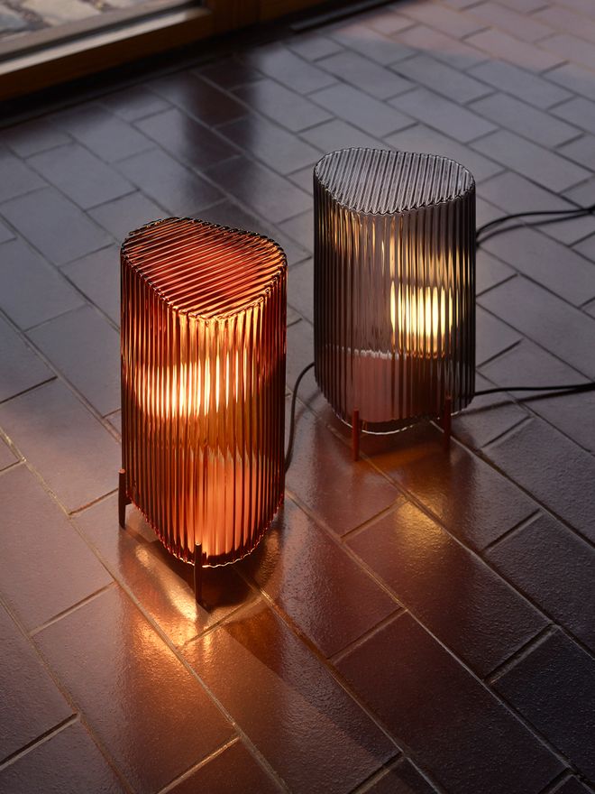 Iittala's Putki table lamp in copper and gray, placed on the floor.