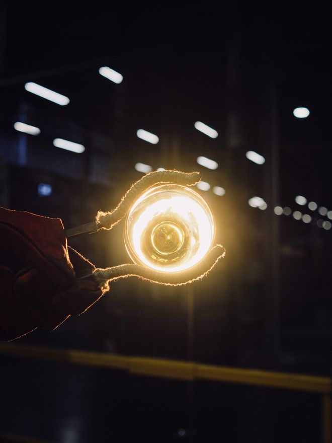 Solare glasses being made at the Iittala Glass Factory: glowing glass held with tongs against the light