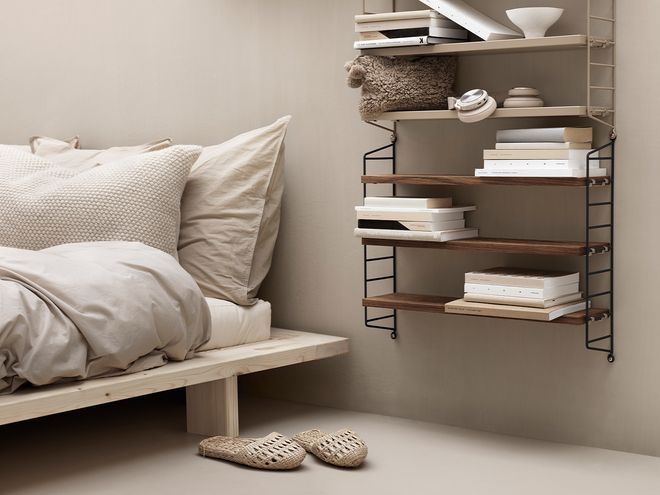 String Furniture's String Pocket shelves in bedroom decor.